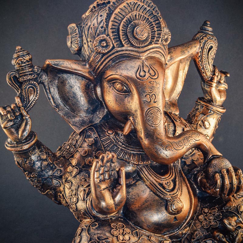 Bronz színű Ganesha szobor, egy ülő elefántfejű istenség szobra.