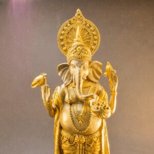 Arany Ganesha szobor, egy ülő elefántfejű istenség szobra arany színűre festve.